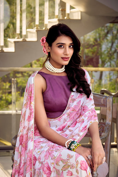 Woman wearing a pink floral print weightless marble saree with pearl lace border and plain Moonga silk blouse, perfect for party wear.