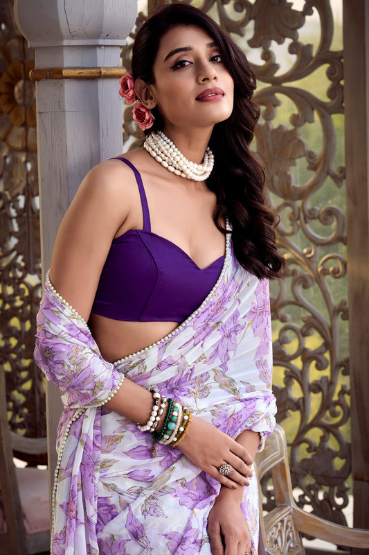 Woman wearing a pink floral print weightless marble saree with pearl lace border and plain Moonga silk blouse, perfect for party wear.